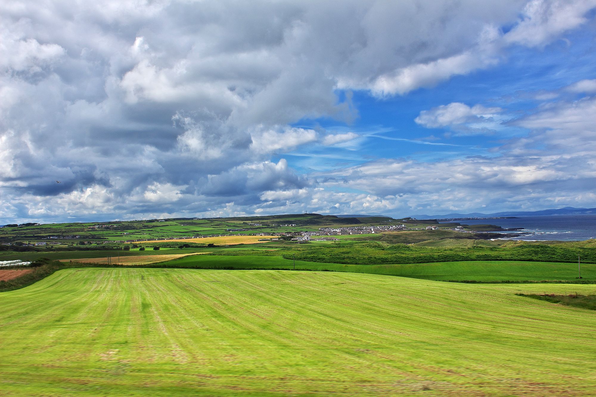 Rolling green fields divided by stone walls in the Irish countryside